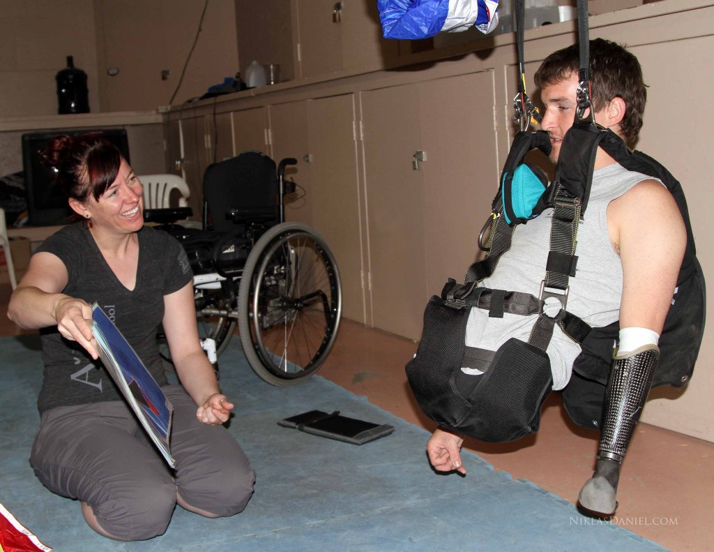 Todd reviews photos of possible canopy malfunctions while suspended in his harness. 